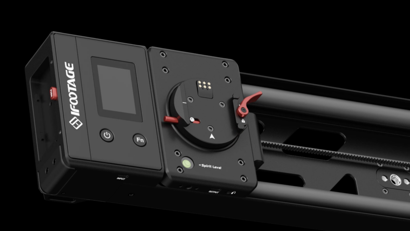 Close-up of a black iFootage camera slider featuring a control panel with a screen on the left, function buttons, and adjustment knobs with red accents. It also has a "Spirit Level" indicator. The equipment is set against a black background.